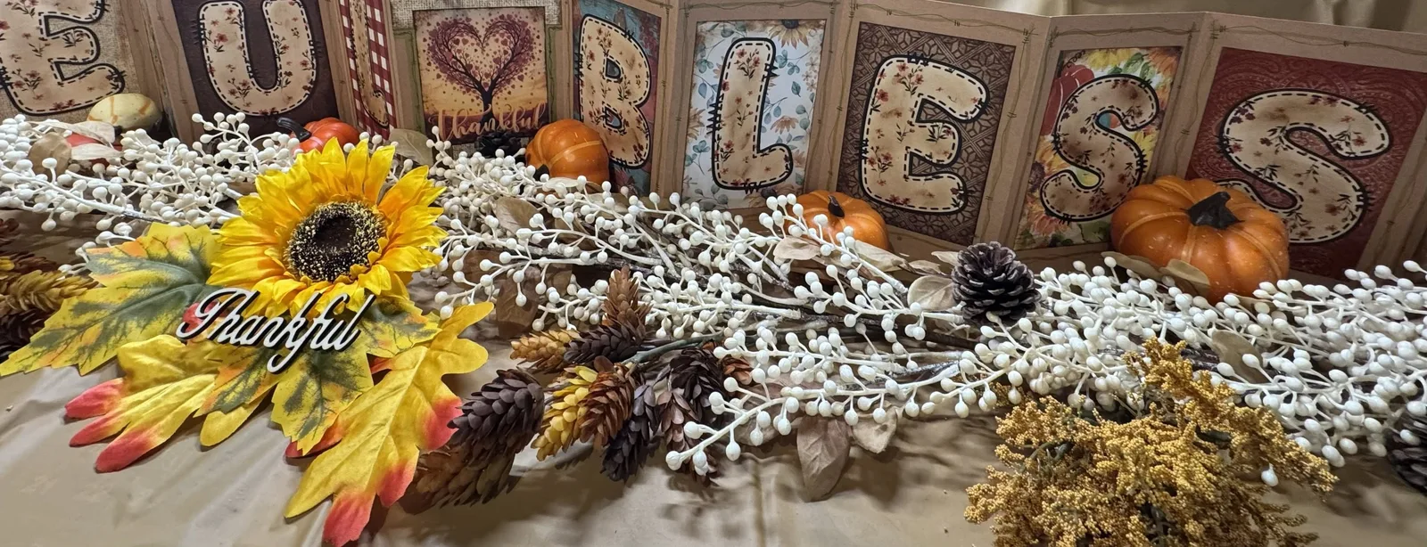 An autumn accordion display with a sunflower, pumpkins and pinecones.