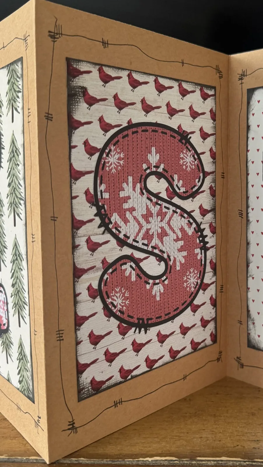 Close-up of a handmade Christmas display with a red letter S and cardinals.