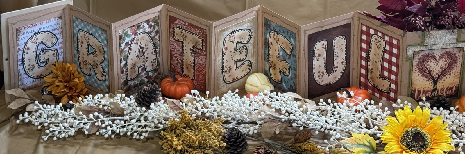 Autumn accordion display spelling Grateful, with seasonal decorations.